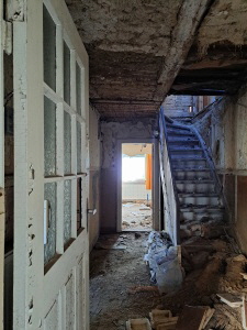 Blick vom Hauseingang in den Flur. Rechts die Treppe nach oben.